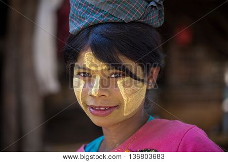 MRAUK-U MYANMAR - JANUARY 27 2016: Unidentified young Myanmar girl with thanaka on her smile face is happiness. Thanaka is a yellowish-white cosmetic paste made from ground bark.