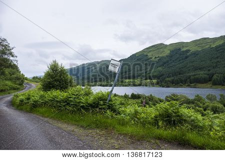 Passing place road sign on narrow single track country road by the side of Loch Doine in Scotland