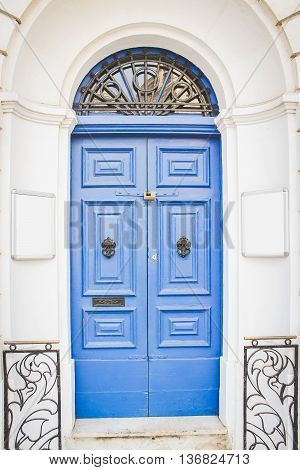 Blue Wooden Doors with Black Metal Knockers and two Empty White Boards from Both Sides for Your text Malta