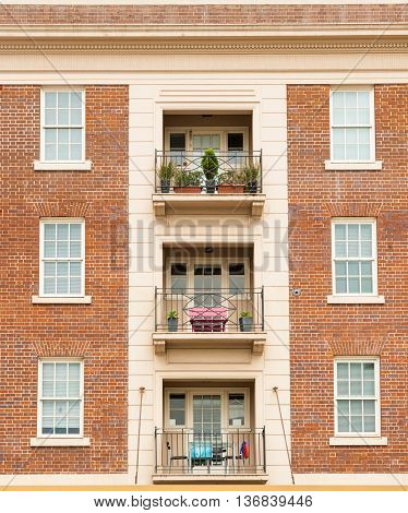 Apartment building extior wall red brick symmetrical architecture with windows and balcomies in three.