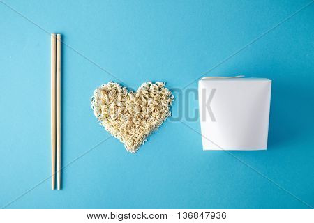 Top view I love wok takeaway noodles presentation with chopsticks, blank box and dry pasta in heart shape isolated on blue mockup