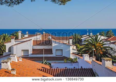 Sea view atop of terracotta tiles roofs. Travel destination. Summer vacations concept. Costa Dorada Spain. Horizontal.