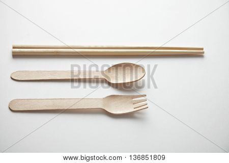 Mixed of kitchen utencils for takeaway: asian chopsticks, spoon or fork made from recycled paper or wood, eco friendly, top view presented top view on white