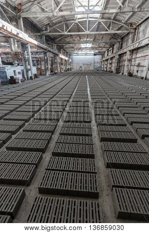 Stack of bricks. Manufacturing of aerated concrete blocks. Manufacturing of cinder block. The plant manufactures building material. The plant produces a cinder block. Cinder block-building material.