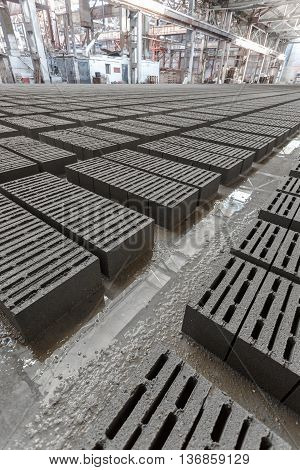 Stack of bricks. Manufacturing of aerated concrete blocks. Manufacturing of cinder block. The plant manufactures building material. The plant produces a cinder block. Cinder block-building material.