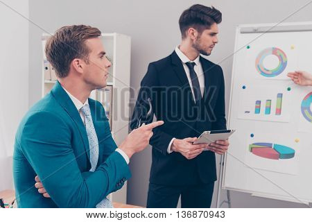 Two Young Businessmen Discussing Diagrama Of  Financial Growth Of Their Company