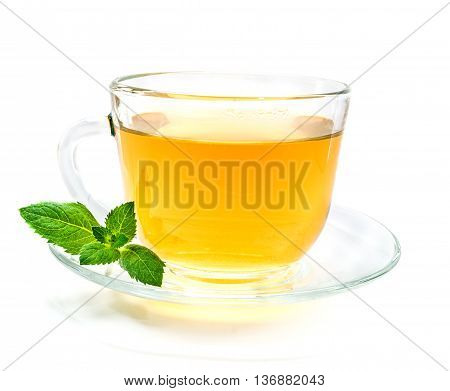 Transparent cup of green chamomile tea with mint leaves on whute background