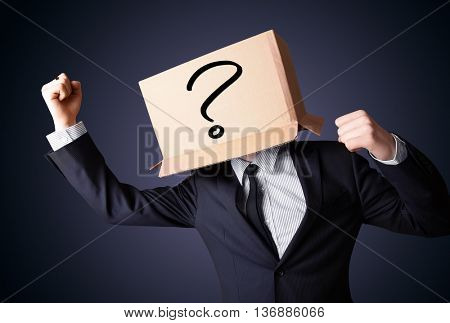 Businessman standing and gesturing with a cardboard box on his head with question mark