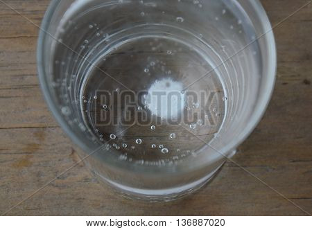 antacids in water glass on wooden table