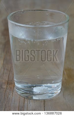 antacids in water glass on wooden table