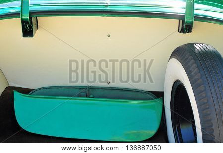 Classic car trunk with spare whitewall tire enclosed.