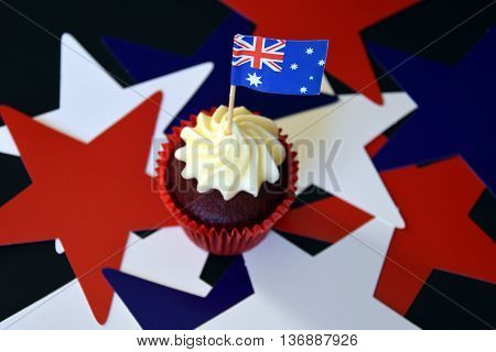 Happy Australia Day party food with red white and blue cupcake and Australian flag. Anzac Day. Celebration patriotism and holidays concept - close up of glazed muffin decorated with australian flag