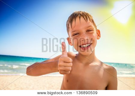 little cude kid with thumb up on the sea