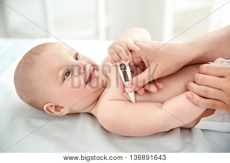 Doctor taking baby's temperature, close up