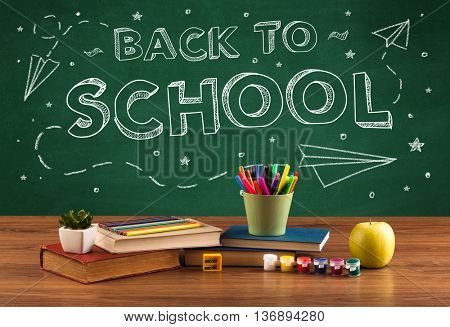 Back to school concepty with writing on blackboard and desk, apple, books, items