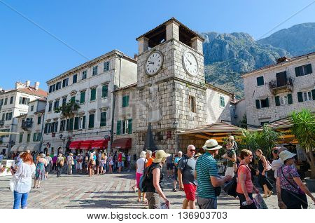 KOTOR MONTENEGRO - SEPTEMBER 22 2015: Unidentified tourists are walking near ancient Clock tower on Plaza of Oruzja in Old Town of Kotor Montenegro