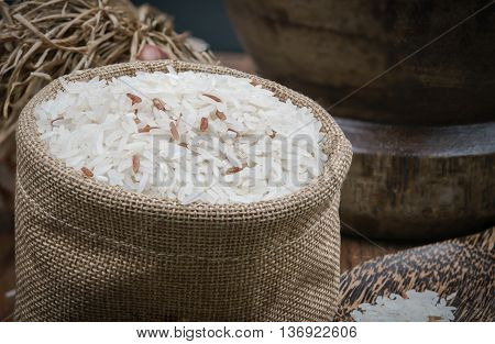 Rice in small sack on dark wooden table