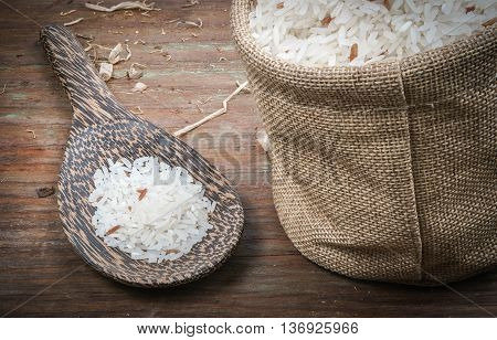 Rice in small sack on dark wooden table