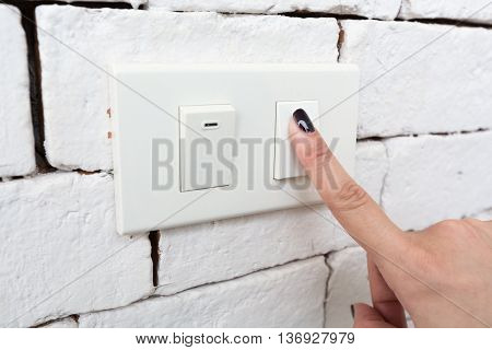 Hand pressing switch off to save energy.