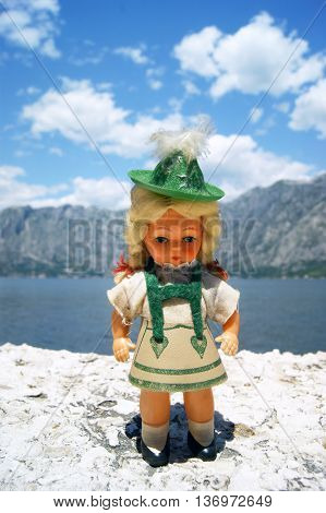 The little doll on the background of clouds and mountains