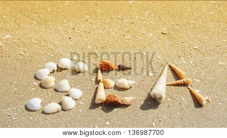 SEA word made of seashells on the sandy beach in Thailand. (warming color tone)