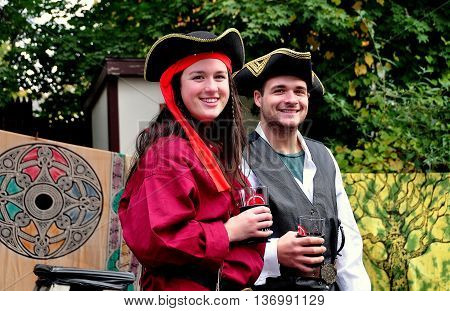 Mount Hope Pennsylvania - October 17 2015: Visitors sporting period clothing strolling with drinks at the annual Pennsylvania Renaissance Faire