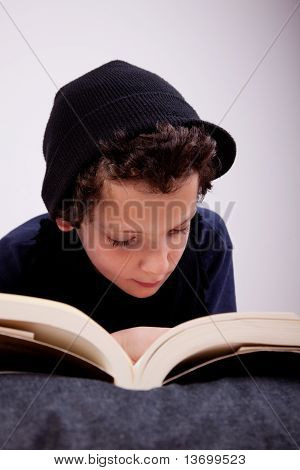 枕に読んで横たわっている少年