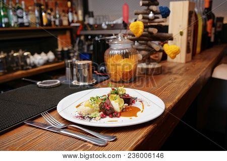 Venison fillet and potato puree served on bar counter, toned photo