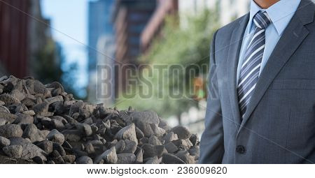 Pile of rubble stone with businessman in city