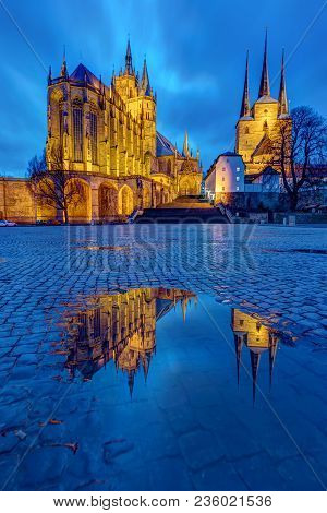 The Famous Cathedral And Severi Church In Erfurt At Dusk Reflected In A Puddle