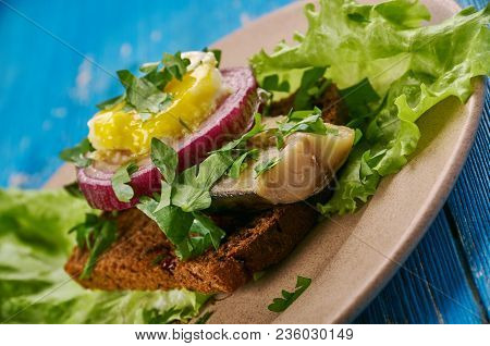 Sol Over Gudhjem - Danish Dish, An Open Sandwich With Rugbrod, Smoked Herring, Chives And A Raw Egg 