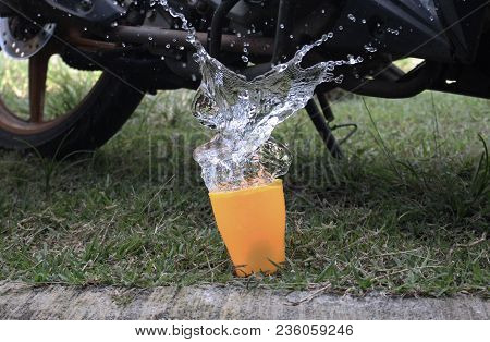 Water Spilled From The Cup, With A Bacground Motorcycle Behind It