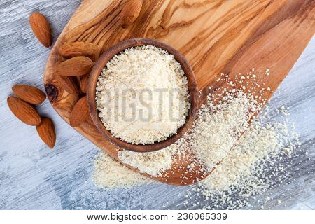 Gluten-free Almond Flour In Wooden Bowl With Almonds From Above On Wooden Table. Coeliac Disease Con