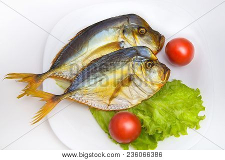 Smoked Fish On White Plate With Vegetables On Isolated Background. Fresh Green Salad And Red Tomatoe