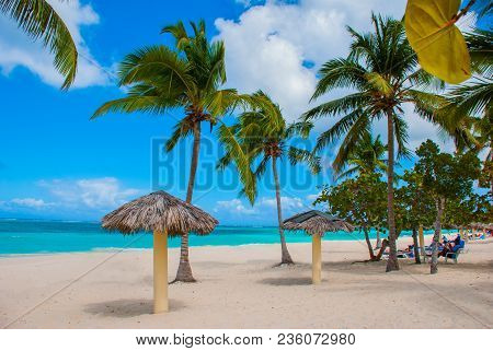 Playa Esmeralda In Holguin, Cuba. Caribbean Sea. Beautiful Paradise Beach: Umbrellas, Sea, Palm Tree