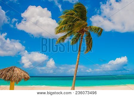 Playa Esmeralda In Holguin, Cuba. Caribbean Sea. Beautiful Paradise Beach: Umbrellas, Sea, Palm Tree