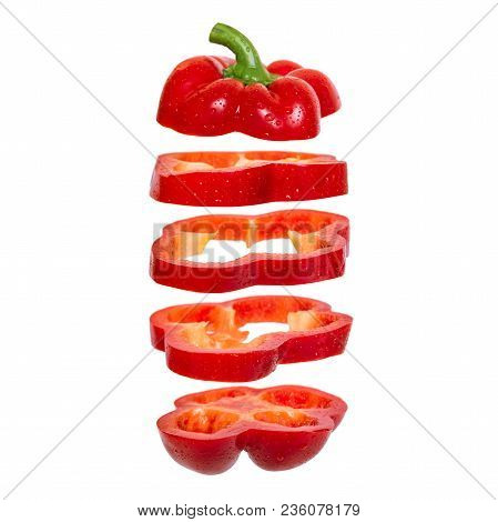 Creative Concept With Flying Red Paprika. Sliced Floating Pepper. Levity Capsicum Vegetable Isolated