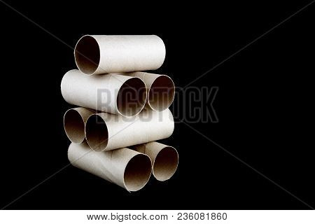 Stacked Toilet Paper Cardboard Tubes Isolated Against A Black Background