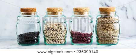 Different Types Of Legumes In Glass Jars With Cork Lids On A Marble Background,  Banner