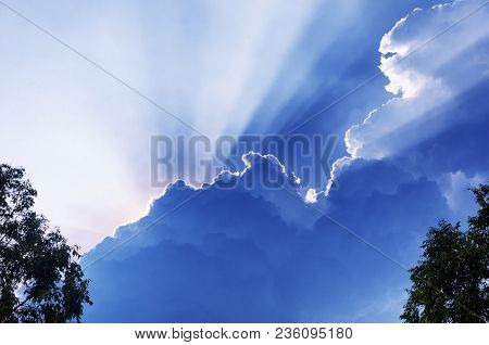 Sun Light Beams Escaping Behiind Large White Puffy Clouds In Vietnam In Southeast Asia.