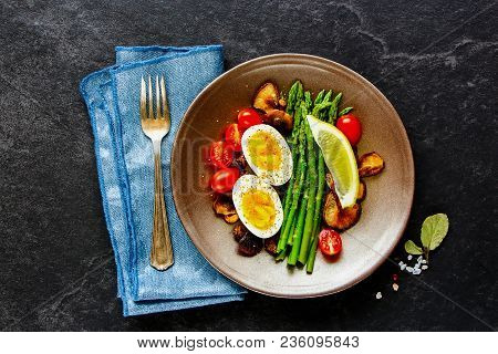 Flat-lay Of Healthy Vegetarian Breakfast Plate. Aspargus, Tomatoes, Mushrooms And Eggs Over Black St