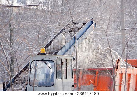 Tractor Cleaning The Road From The Snow. Excavator Cleans The Streets Of Large Amounts Of Snow In Ci
