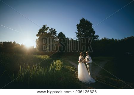 The Bride And Groom At Sunset On A Dark Background