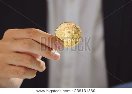 Golden Bitcoin In A Businessman Hand, Digitall Symbol Of A New Virtual Currency