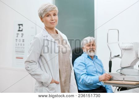 Doctor Ophthalmologist Staying In Front Of Old Patient.