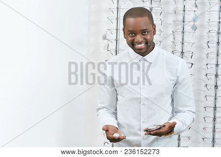 Frontview Of Smiling Man Trying On Eyeglasses In Optical Shop. Model Is Wearing Snowwhite Classic Sh