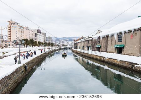 Otaru, Japan - March 5, 2018 : Tourist Walking  On Footpath With Snow Beside Otaru Canal