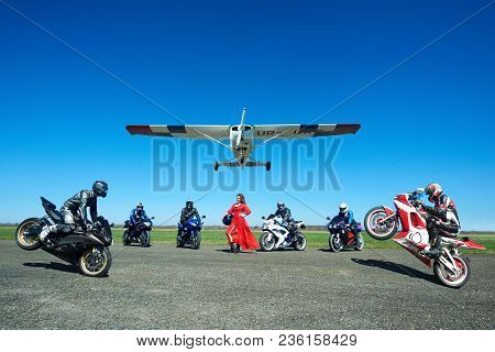 Kiev, Ukraine - 29 March 2017: Frontview Of Seven Ang Young Woman Bikers Making Tricks On Their Moto