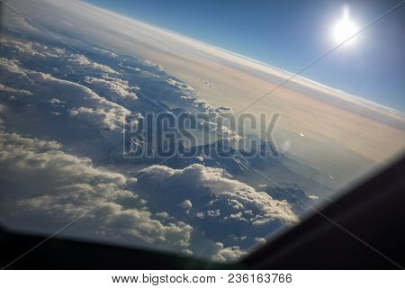 View from a cockpit of a commercial airliner airplane over a beautiful mountain range