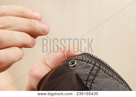 Hands Of Snipper Sew Black Cotton Clothes With A Needle Close Up